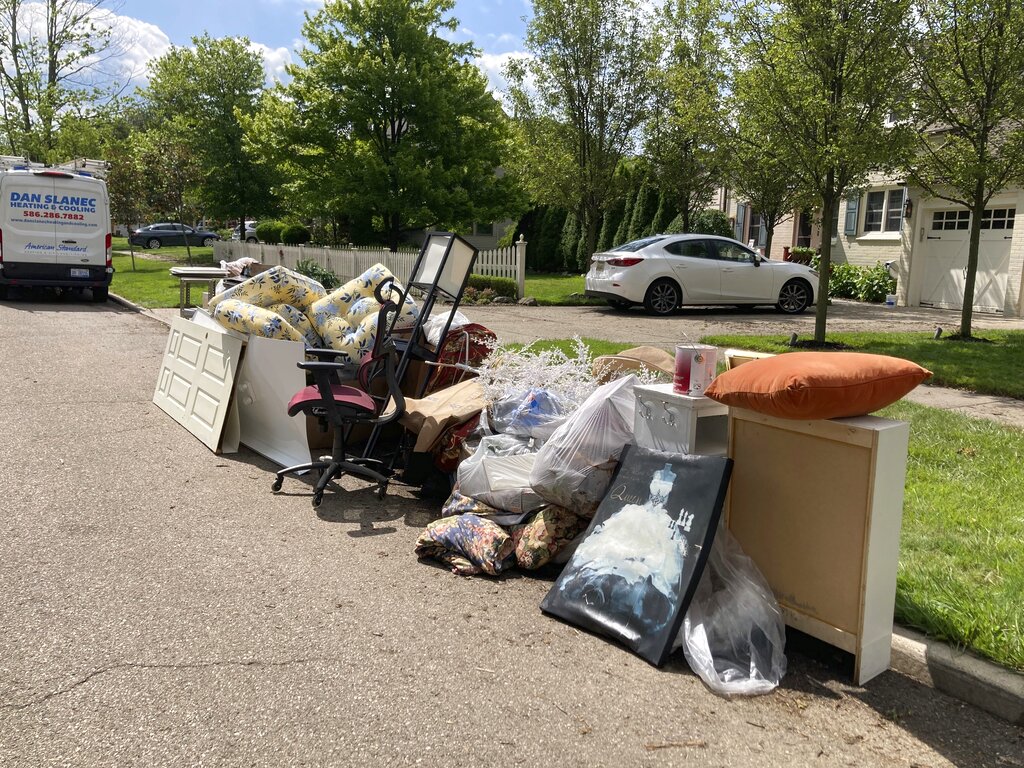 Flood-damaged belongings piled at the curb in Grosse Pointe Farms, Mich. after regional flooding. (AP Photo/Ed White)